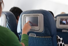 woman choosing movie on plane